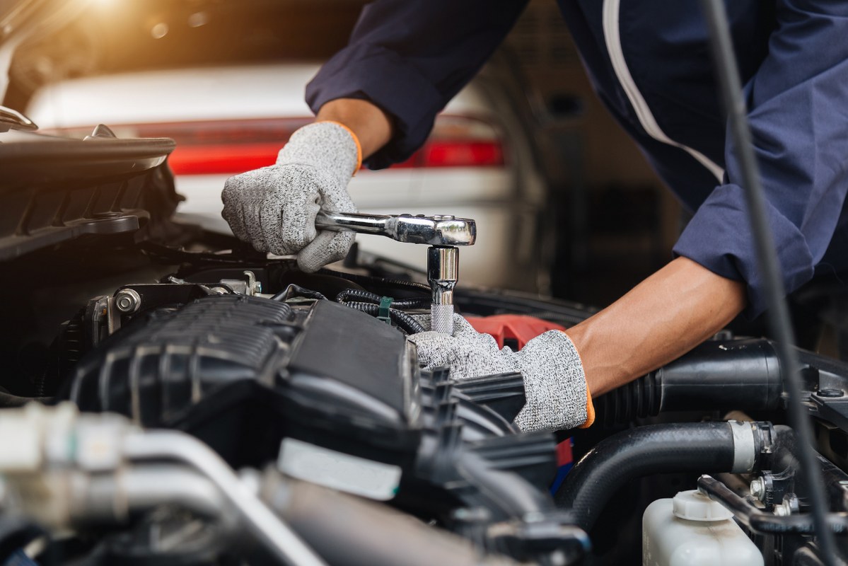 Hands of mechanic repairing car.