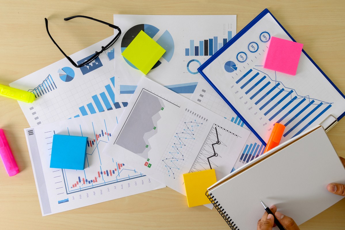 Hands with paper and pen above Market Research papers.