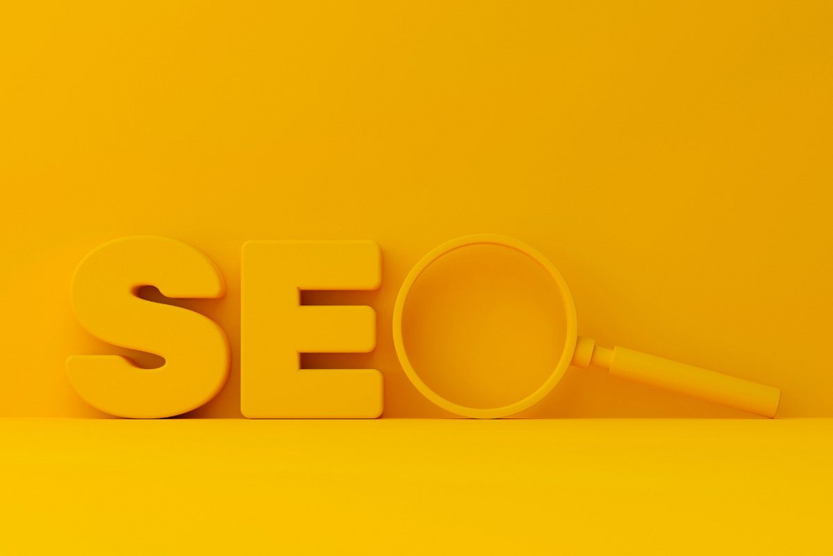 Letters SE with magnifying glass as letter O in 3d rendering against yellow background.