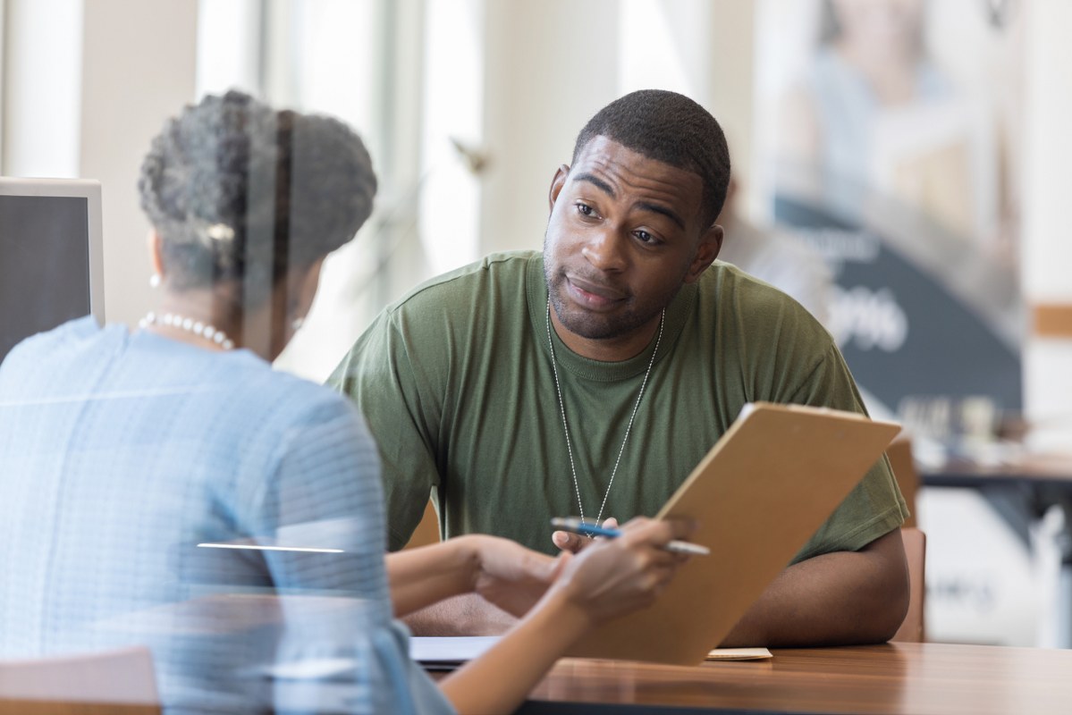 Loan officer reviews loan application with veteran.