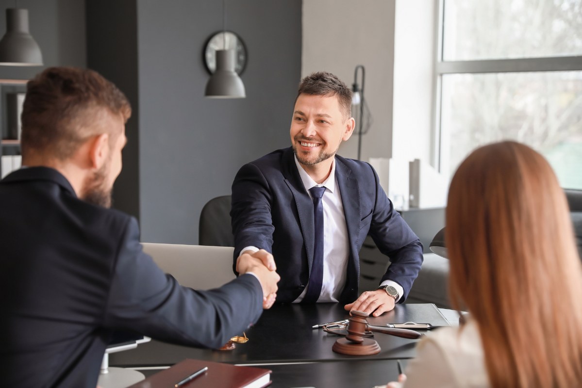 Male Business attorney shaking hands with clients.