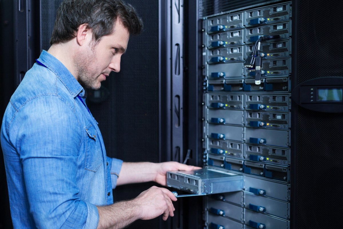 Male IT Technician Installing blade Server in rack.
