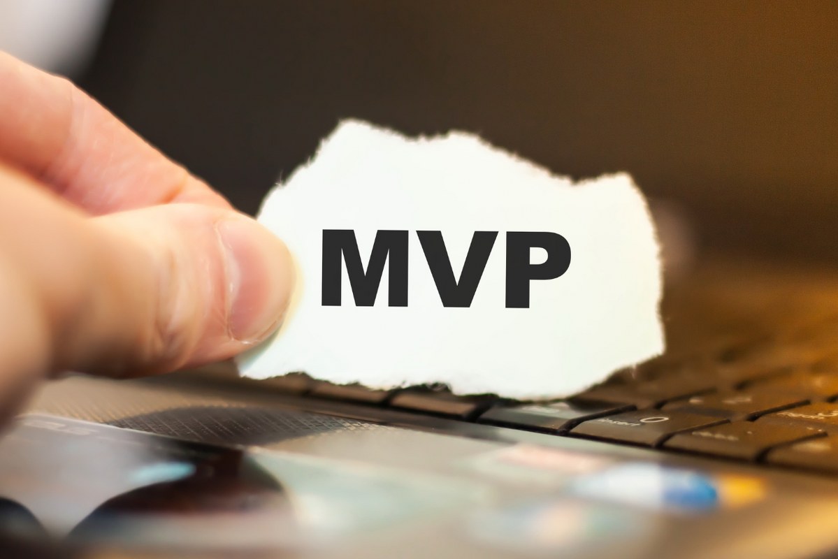Male hand holds the word MVP on the background of the tablet.