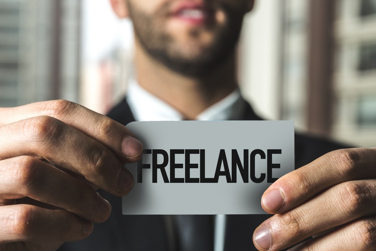 Male holding freelancer sign card.