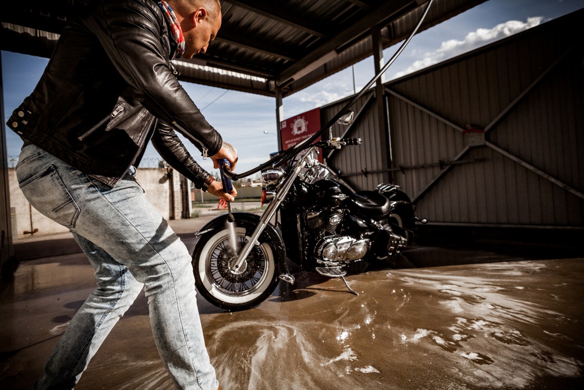 Male owner cleaning his own motorcycle.