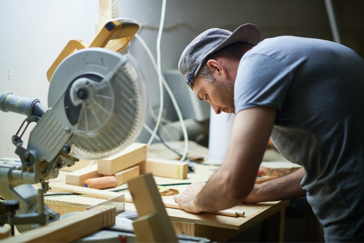 Male working on wood at workplace.