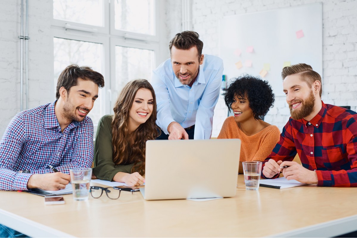 Marketing agency coworkers discussing new project on laptop.