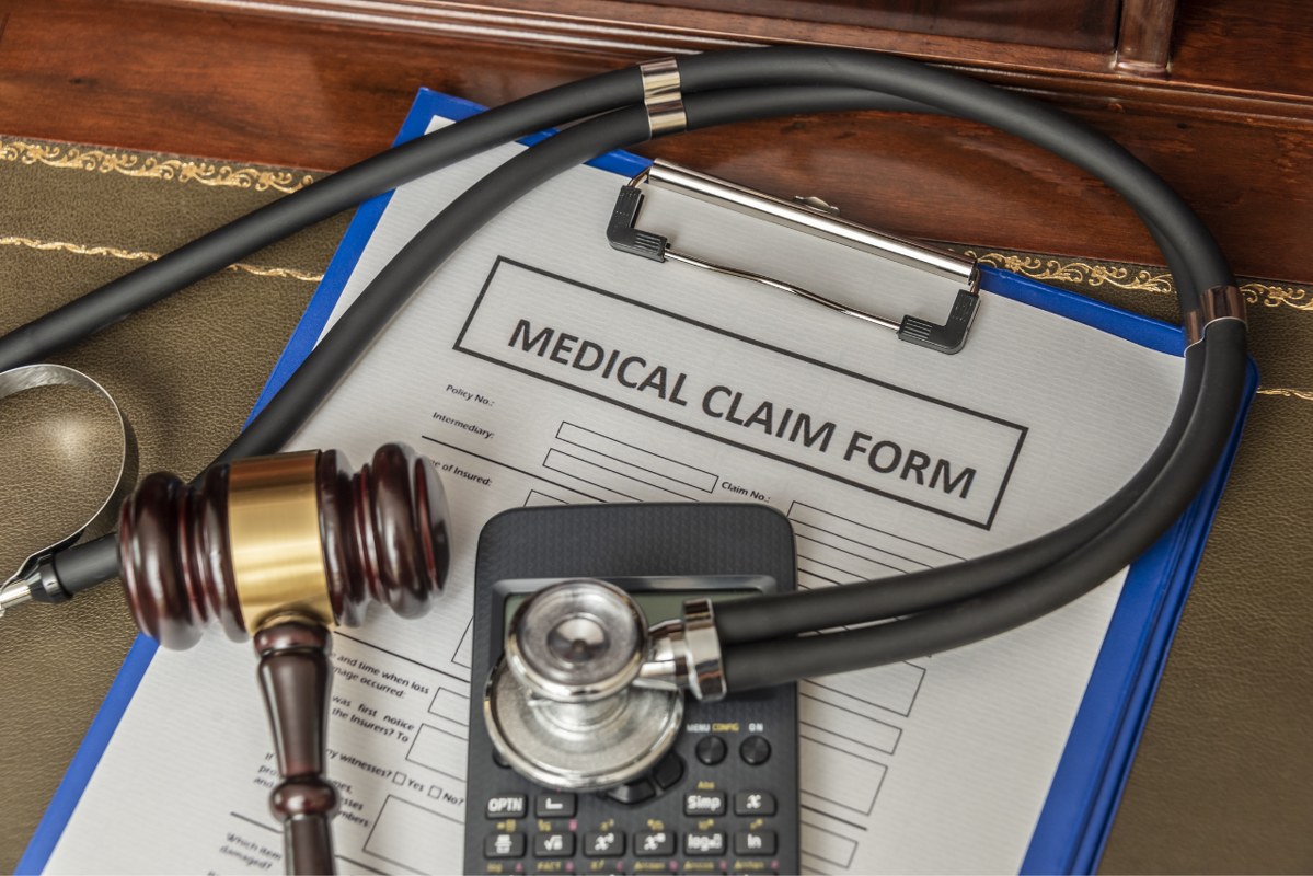 Medical Claim Form with Stethoscope and Gavel.