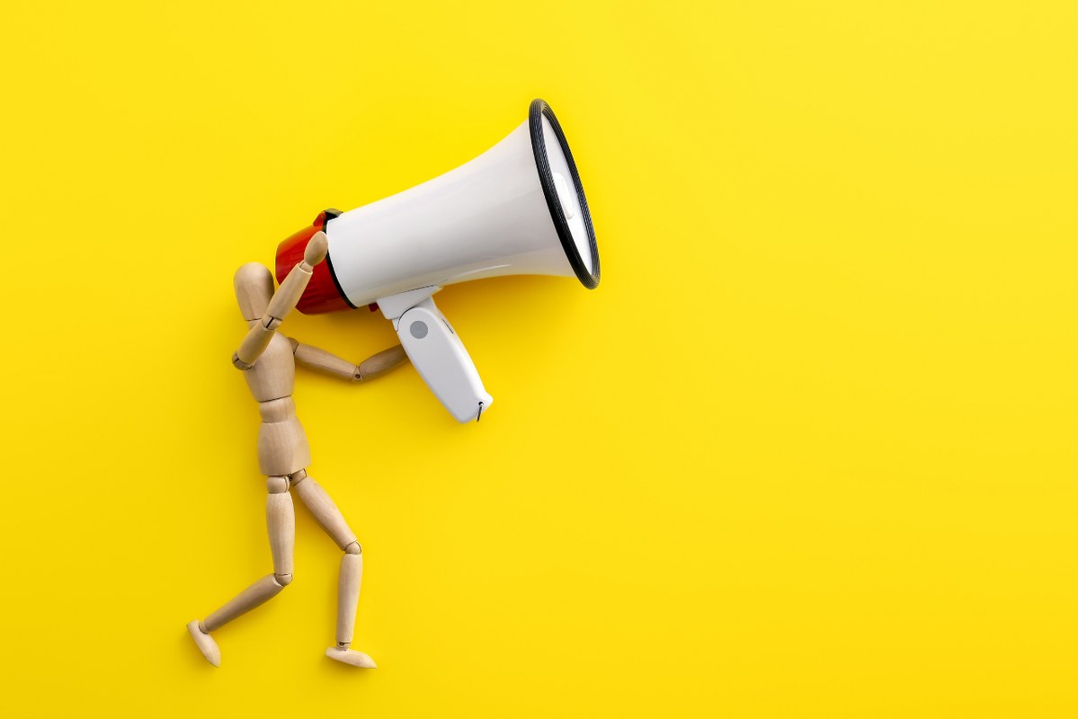 Megaphone with Mannequin on Color Yellow Background.