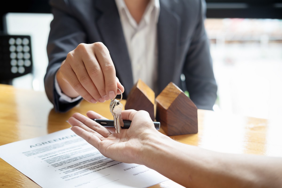 Midsection view of female Real Estate Agent Giving Keys to Client.