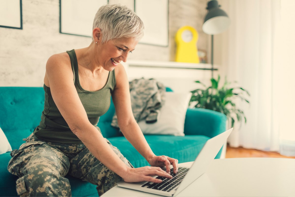 Military woman works on online business at home.