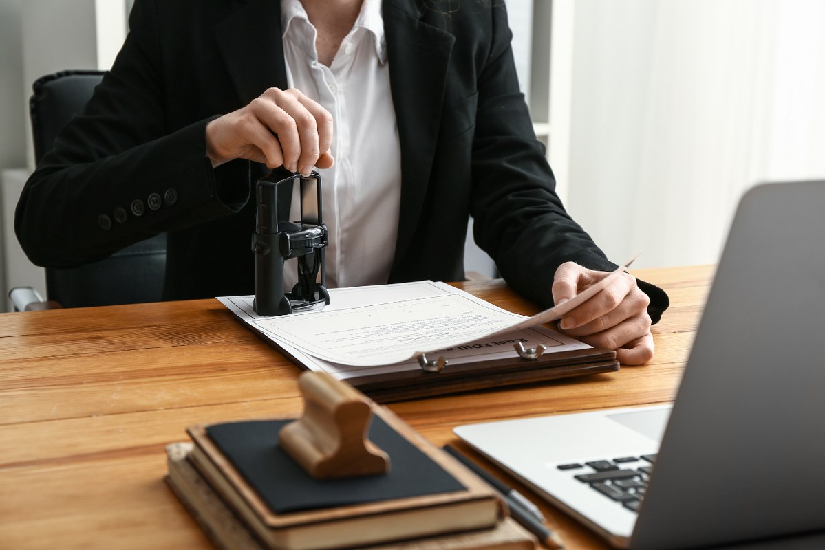 Notary Public Stamping Document in Office.