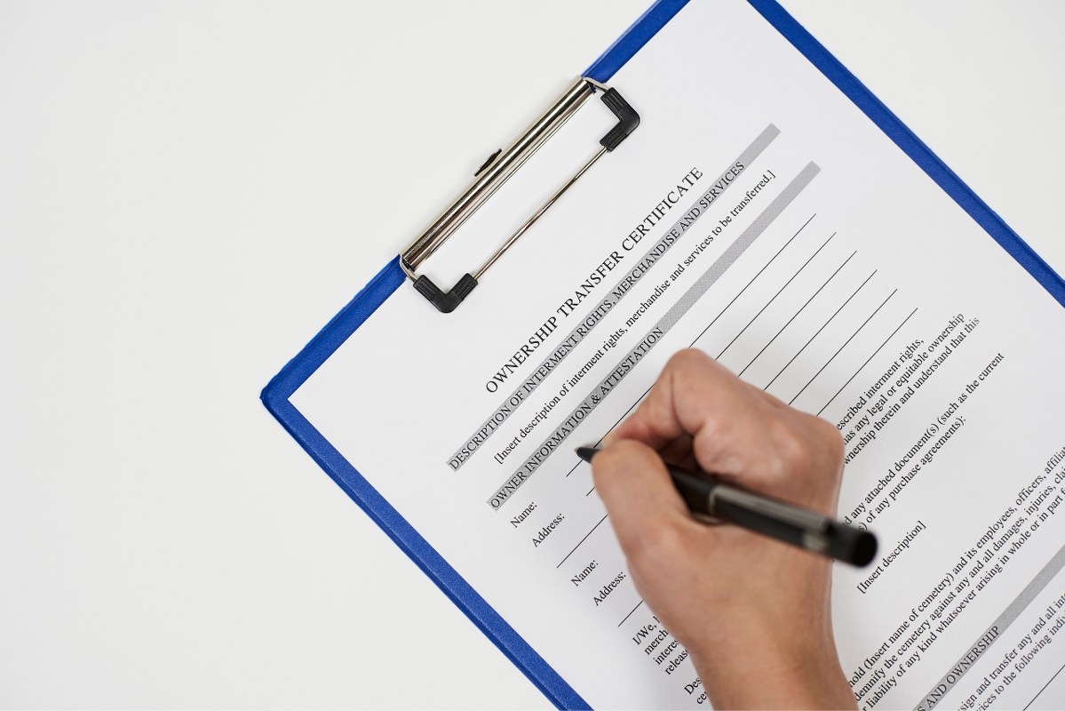 Person filling out ownership Transfer Certificate.