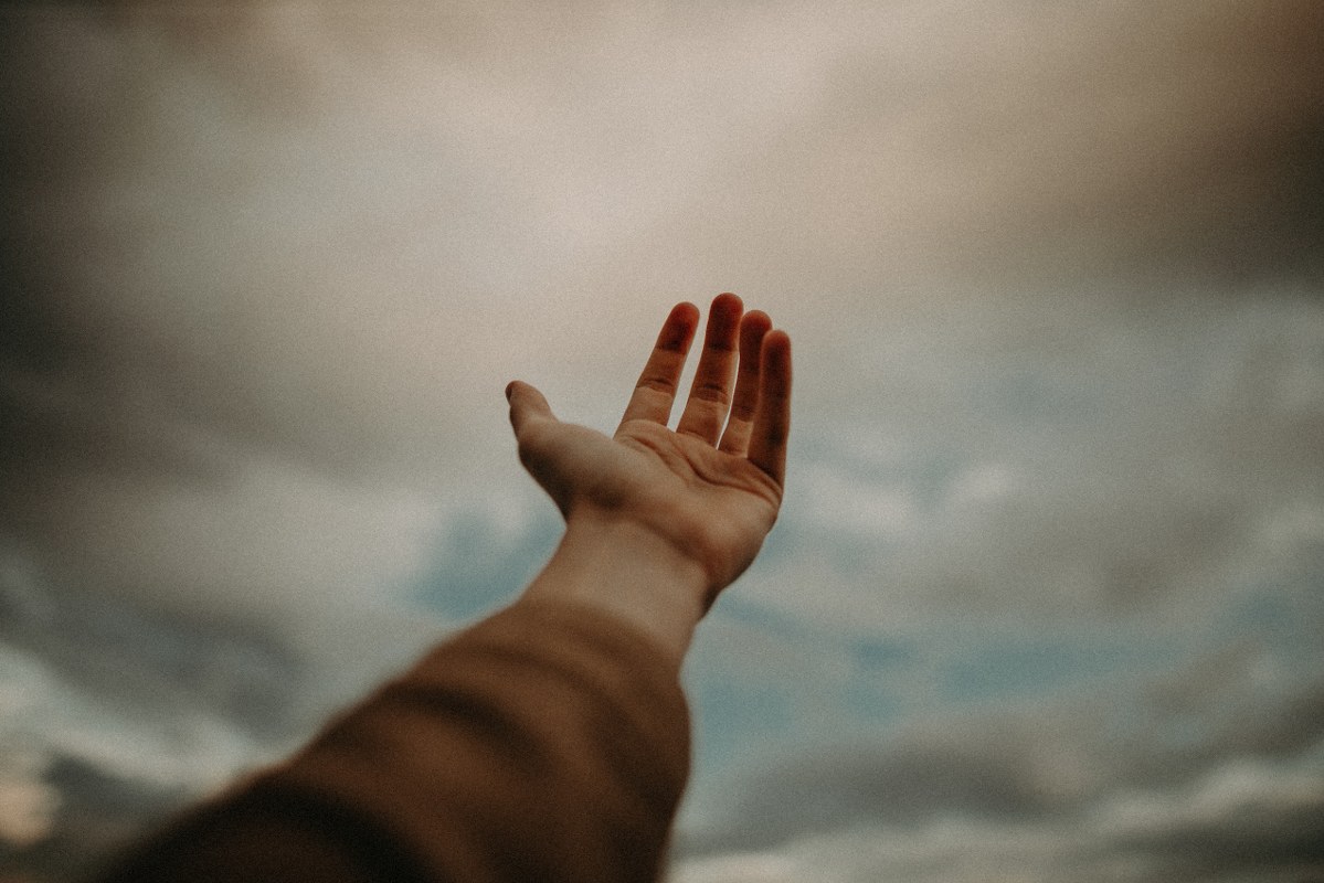 Person's Hand Reaching Out to the Sky.