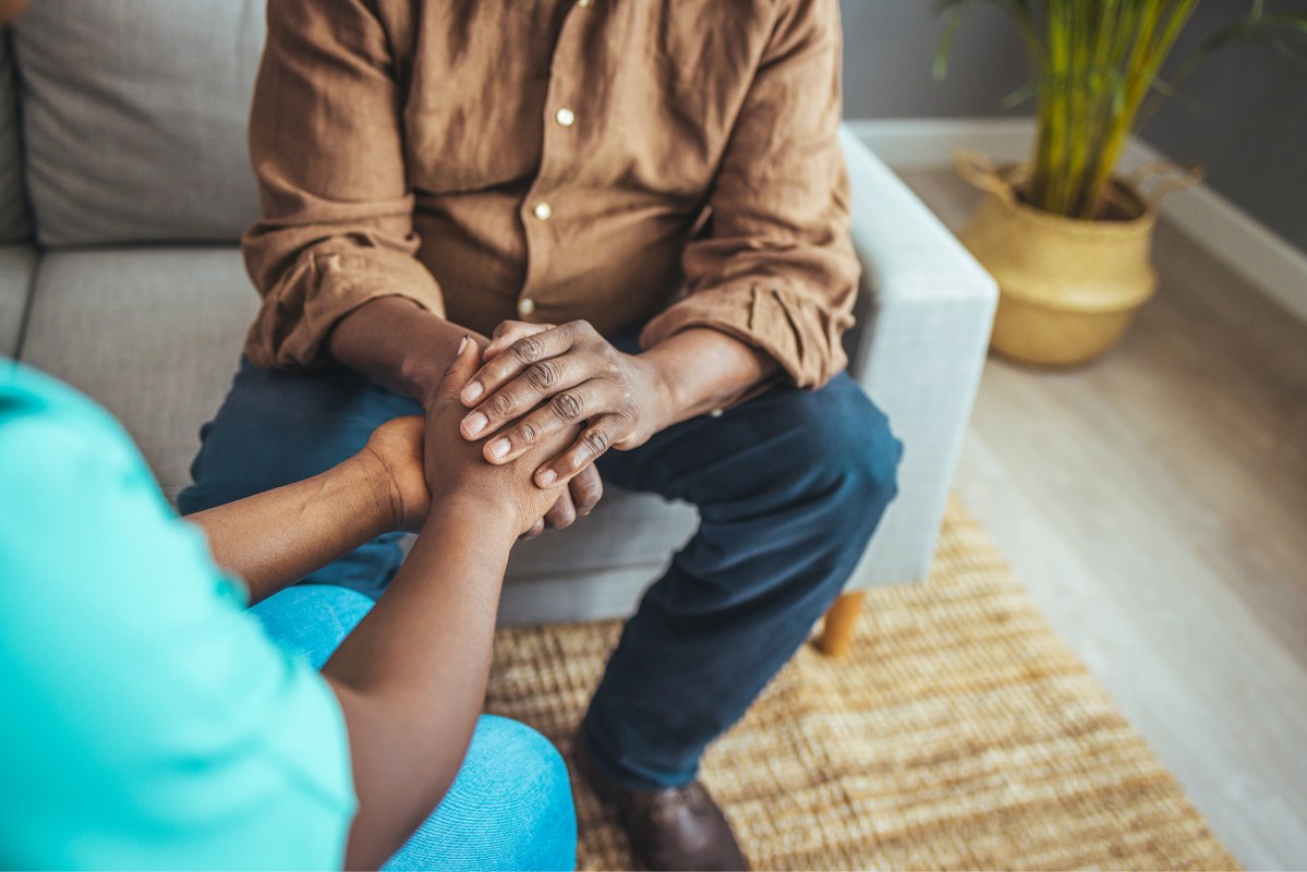 Salesperson shows empathy by holding client's hand.