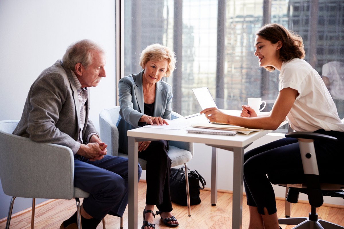 Senior Couple Meeting with Female tax consultant in Office.