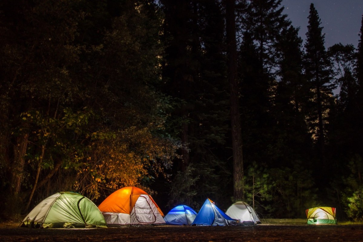 Several tents outdoors at night.