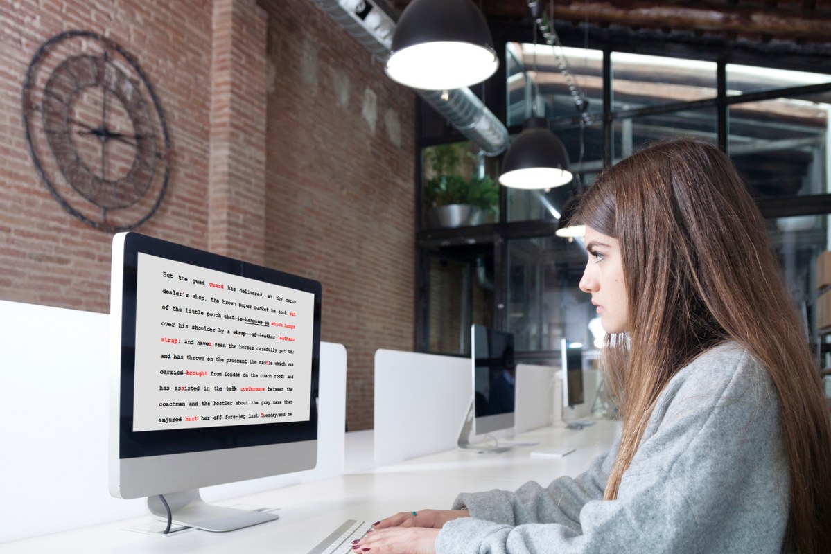 Sideview of female proofreader working on desktop.