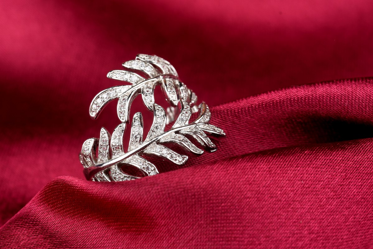 Silver jewelry placed on red clothe.