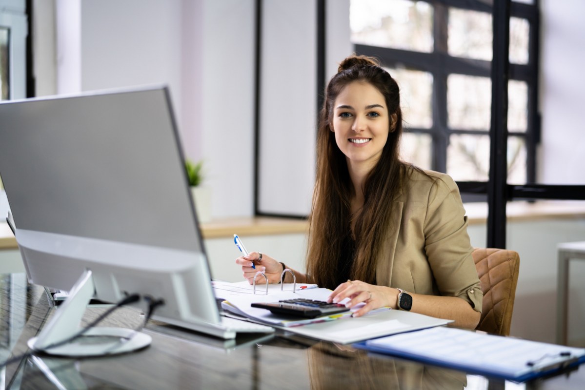 Solo female business owner working on taxes on her desk.