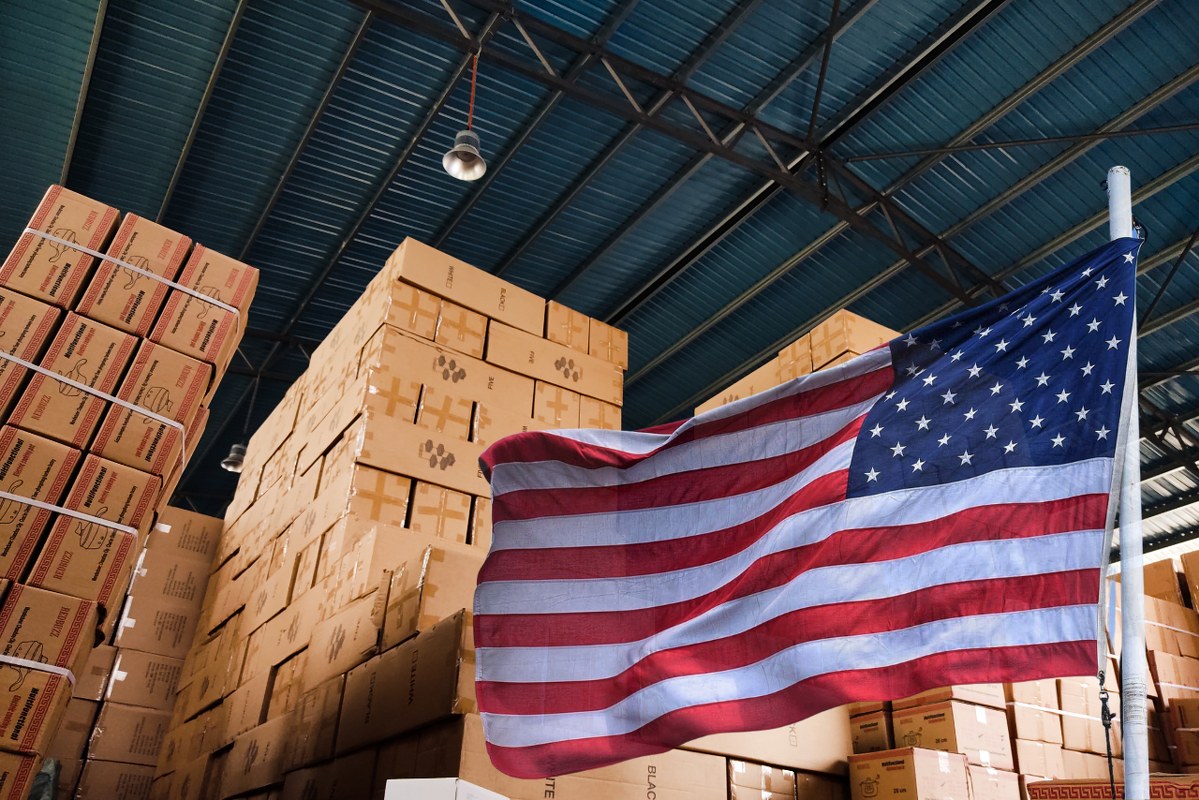 Stacked Boxes in a Warehouse with US flag.