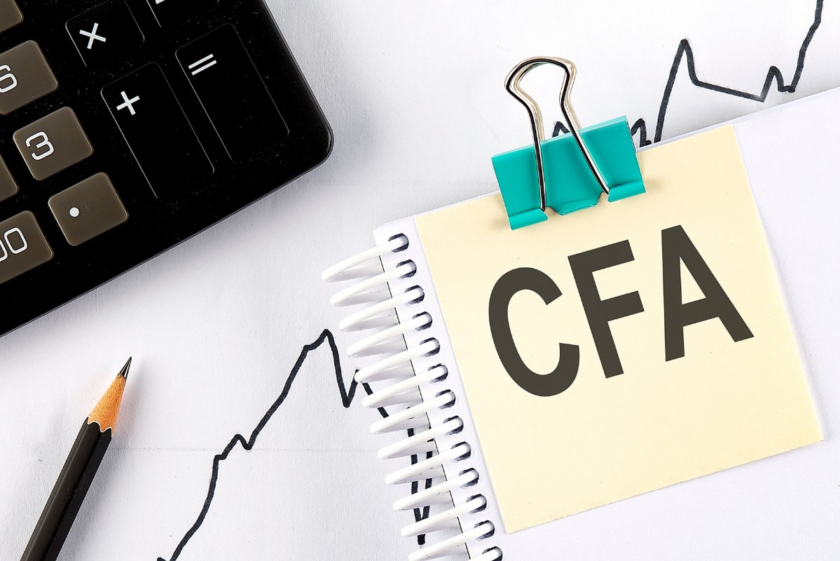Stickers with pencils and notebook with text CFA on chart background.