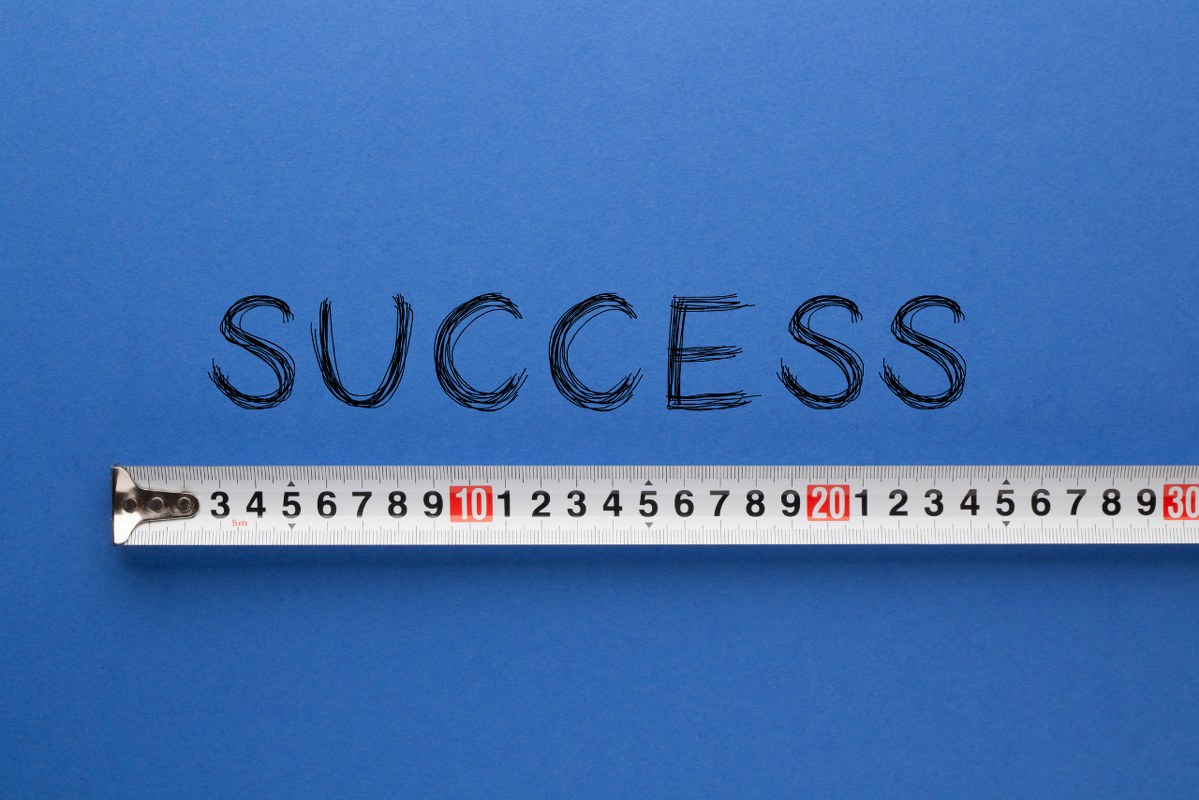 Tape measure pressed against the word success.
