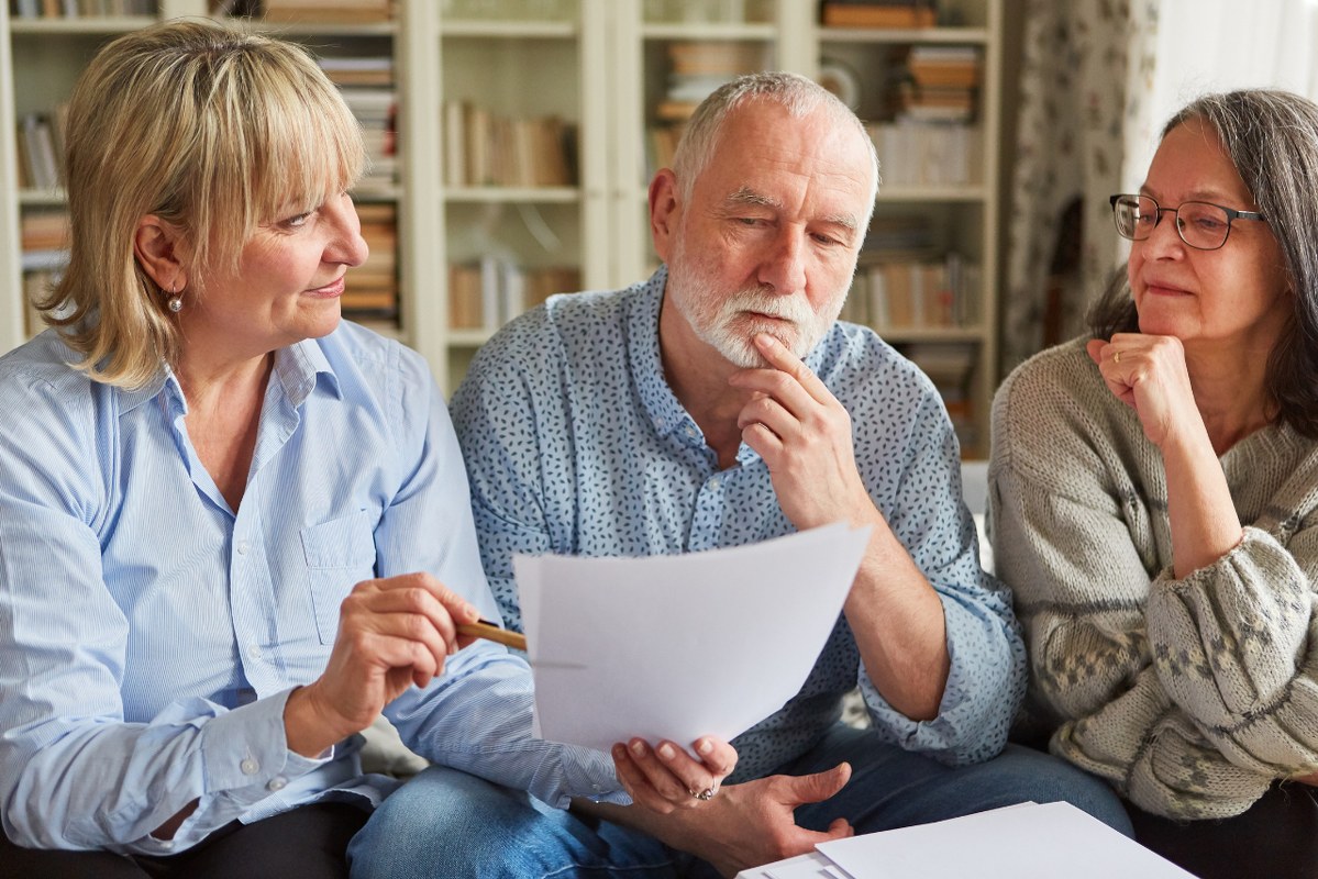 Tax Consultant and Seniors Look at a Form.