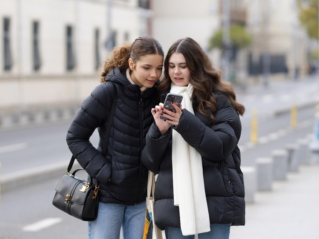 Two people engrossed on a phone.