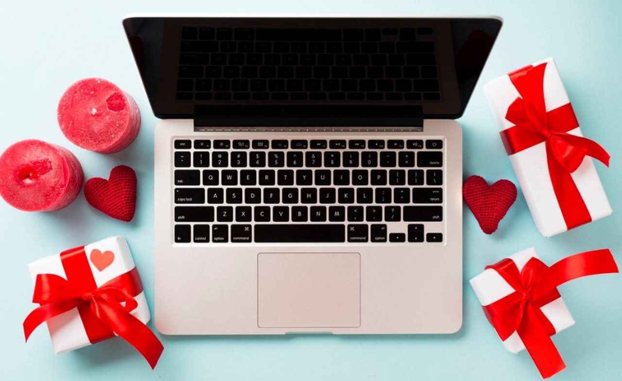 Valentine's day gifts around a laptop.