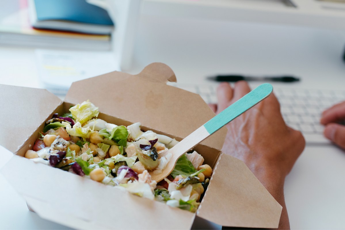 Vegan Salad Takeaway with Man's Hands Typing on Laptop.