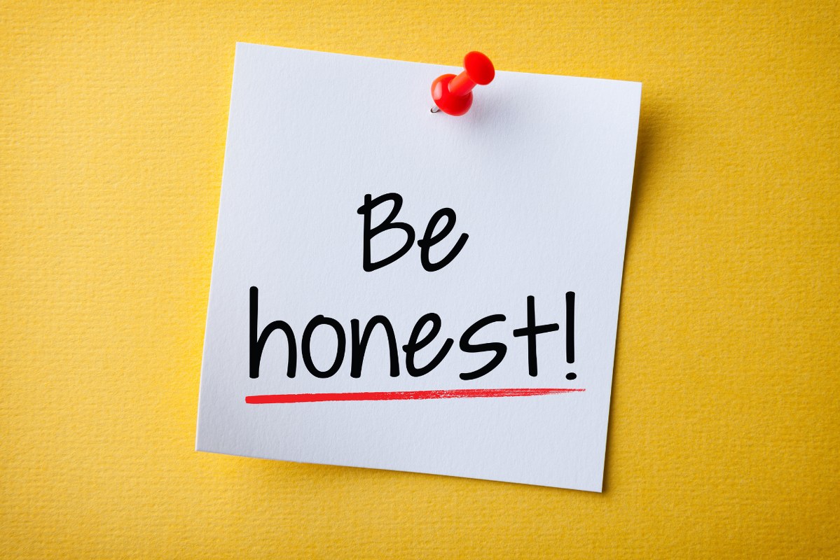 White Sticky Note With Be Honest And Red Push Pin On Yellow Background.