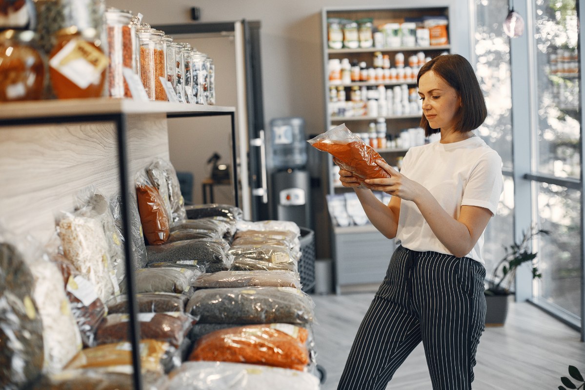 Woman Choosing Spices at the Grocery Store.