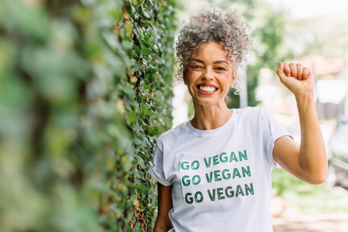 Woman happily wears go vegan shirt.