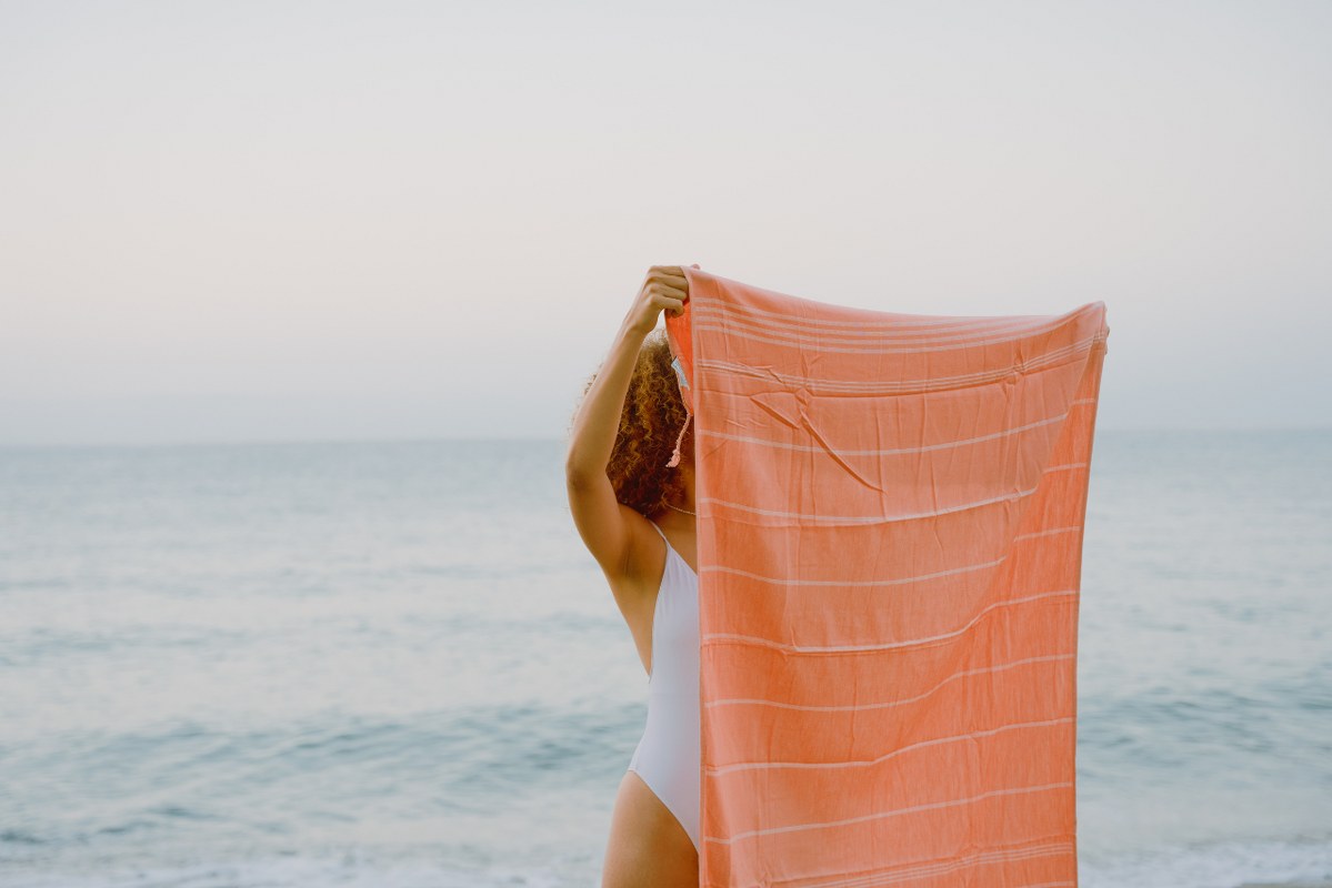 Woman holding oversized beach towel.