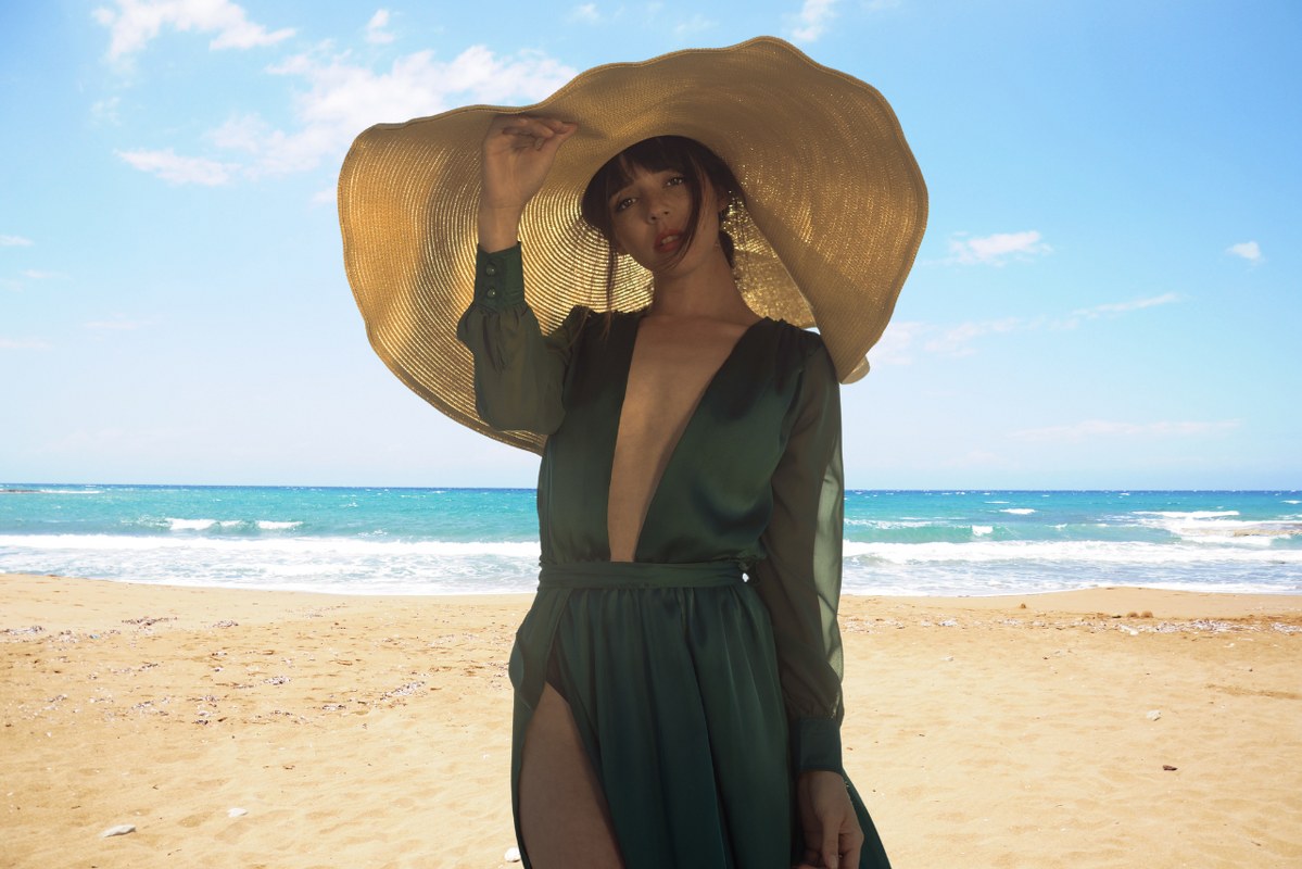 Woman in green dress wearing Floppy Sun Hat.