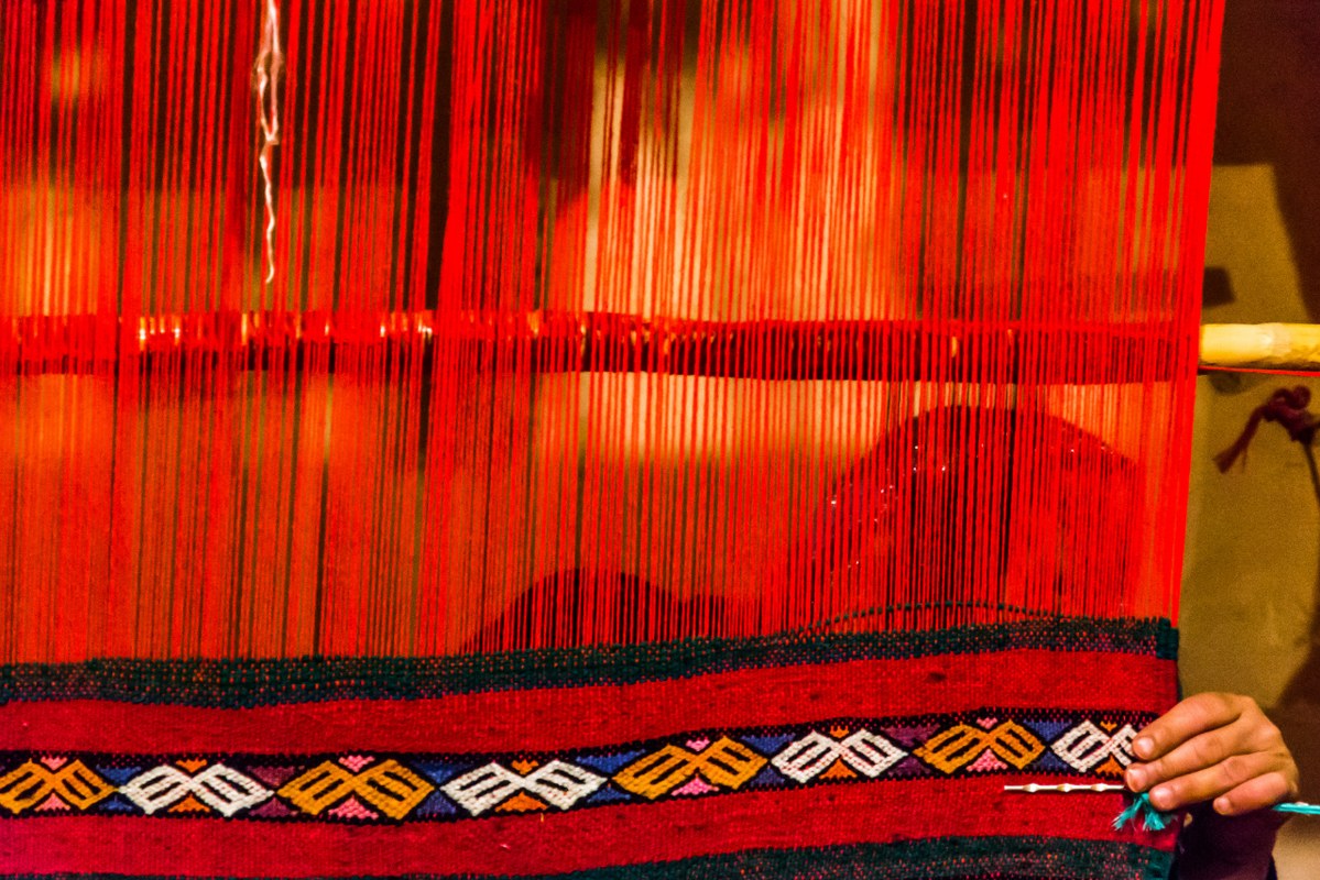Woman making rugs the old fashion way.