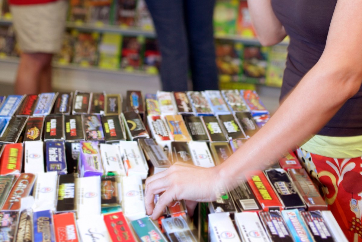 Woman picking up a board game at store.