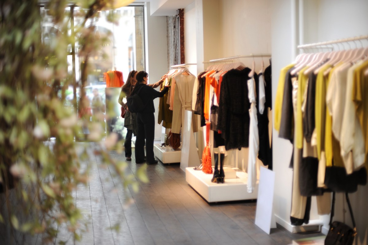 Women browsing and trying on dresses in a boutique.