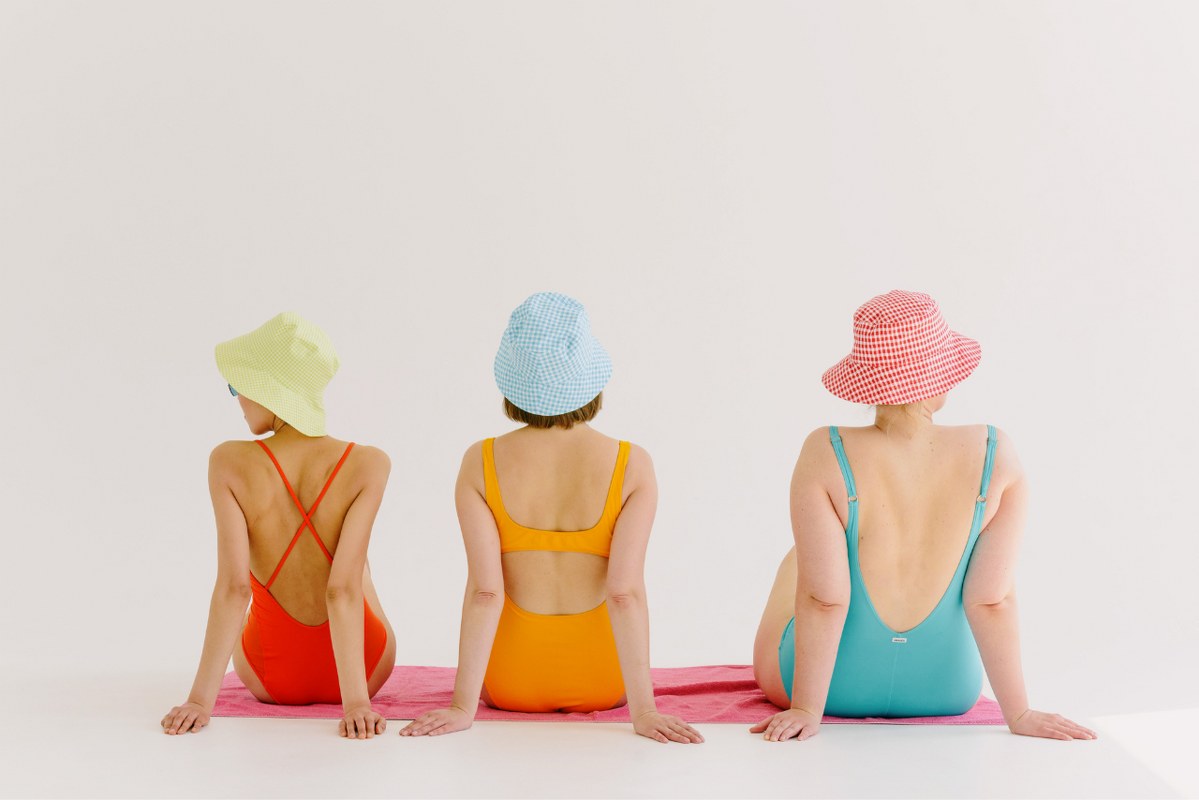 Women in Swimwear Sitting backview on a Towel.