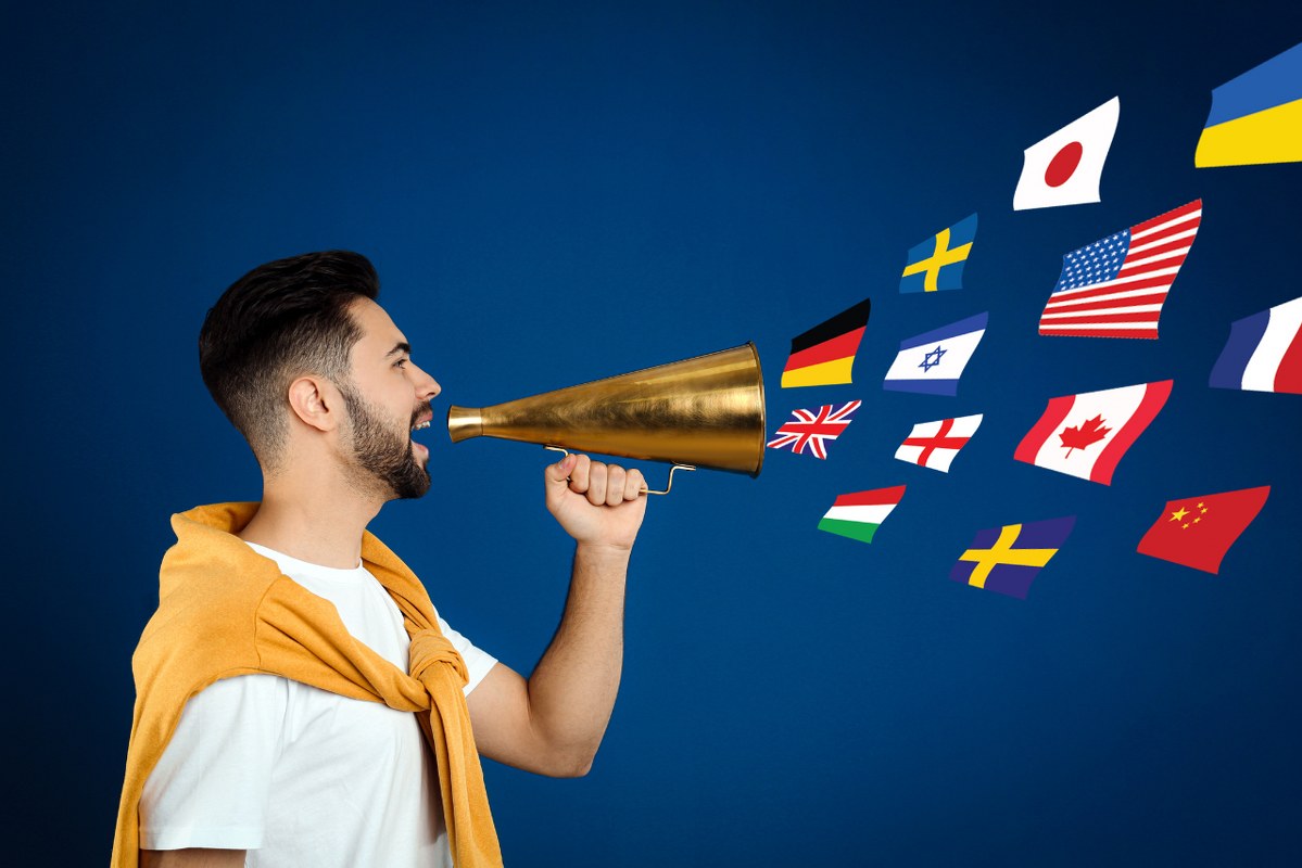 Young Man that can speak multiple languages with Megaphone on Blue Background.