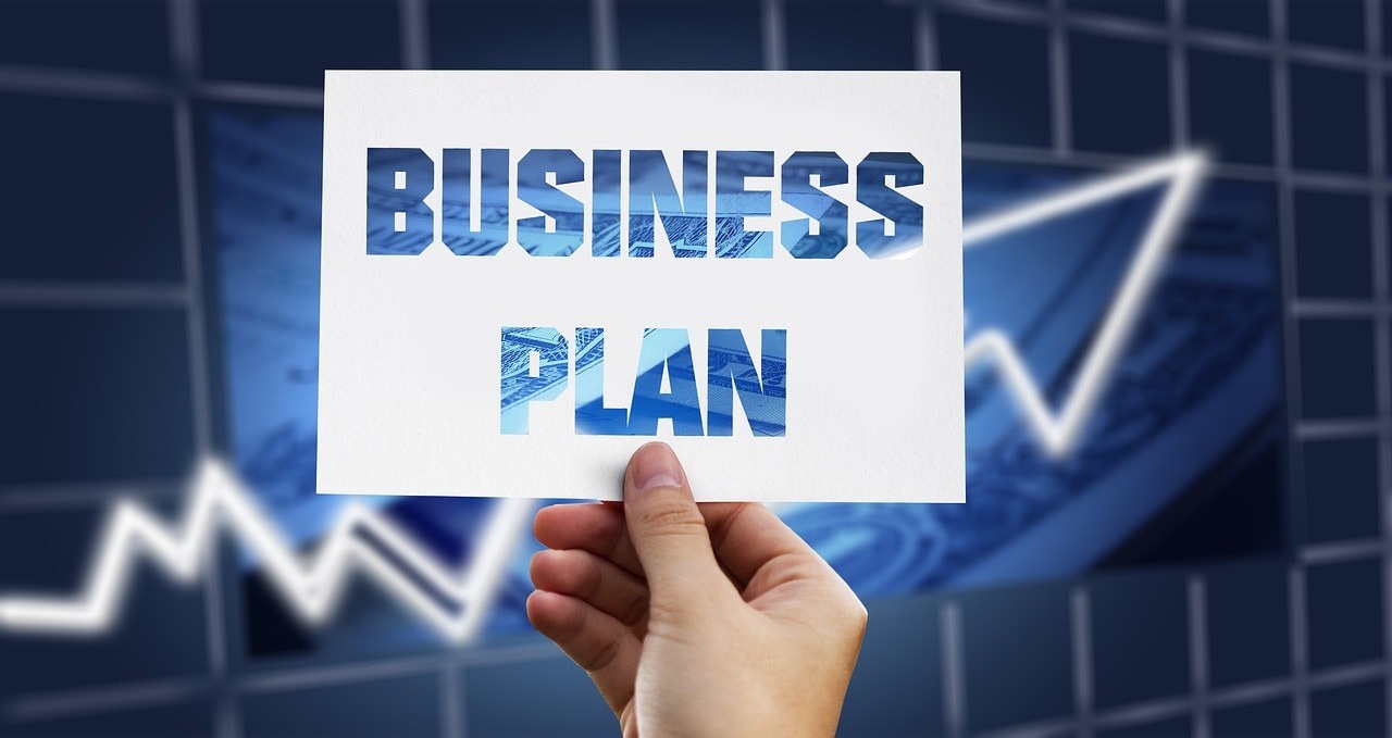 A person holding a card written 'business plan.'