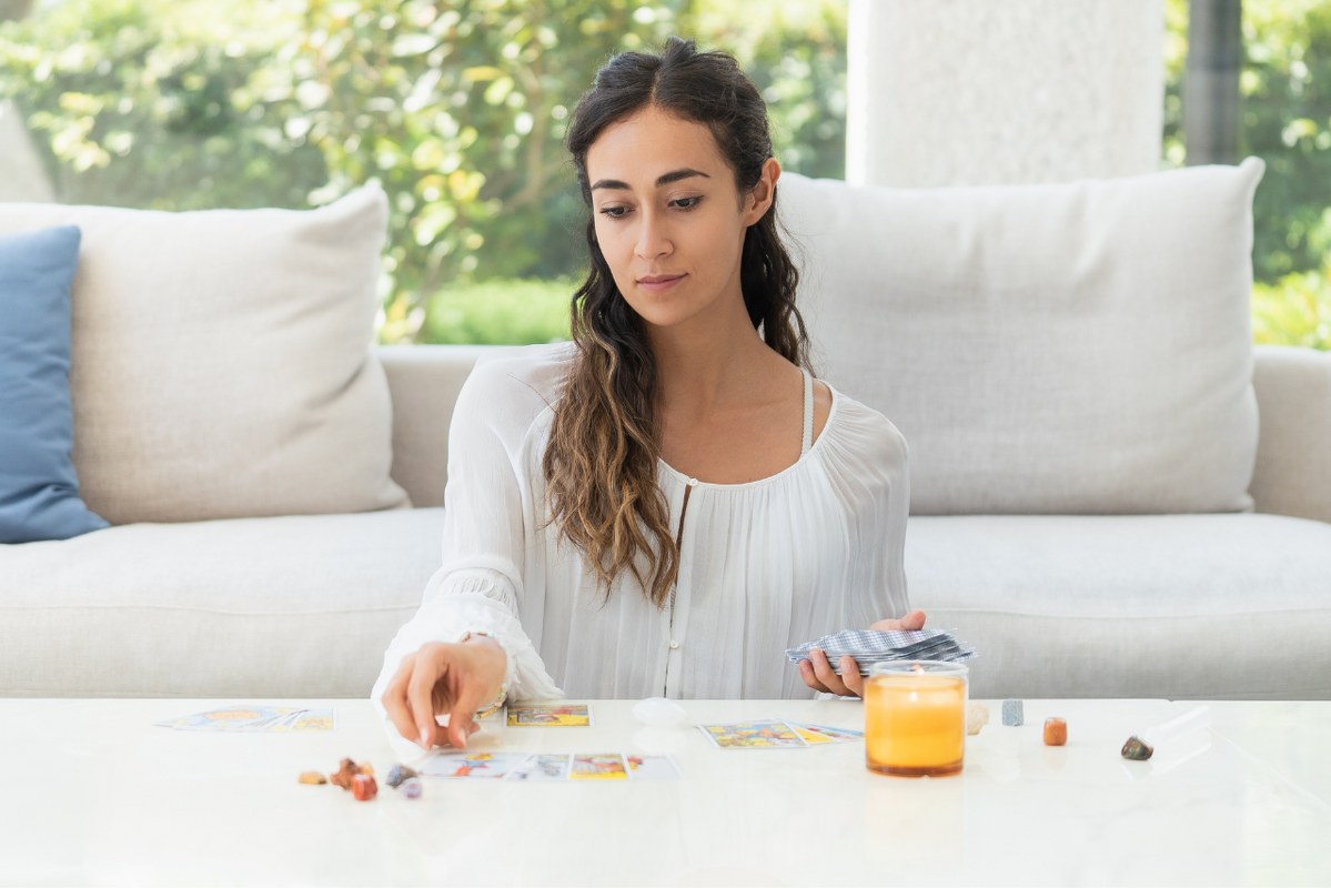 A Woman using Tarot Cards at home.