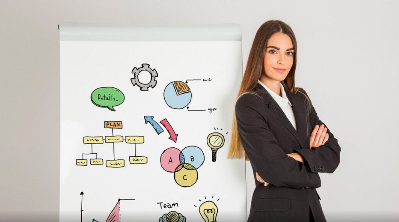 A businesswoman standing next to a whiteboard.