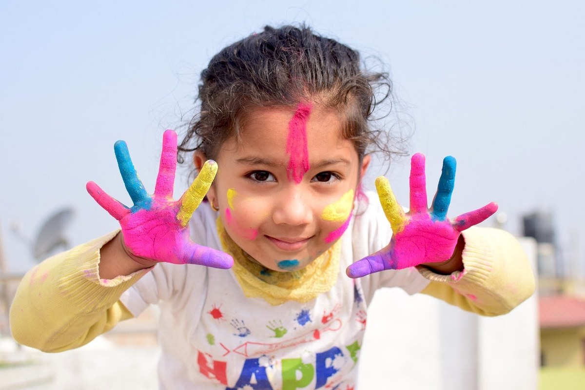 A girl with colored hands and face.
