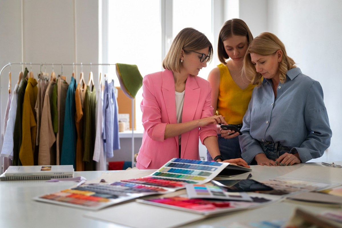 A group of women is discussing topics in a garment office.