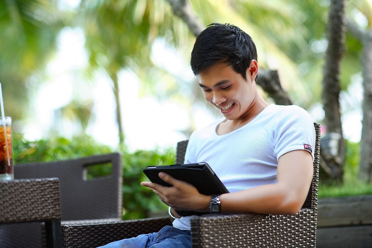 A happy man using his iPad.