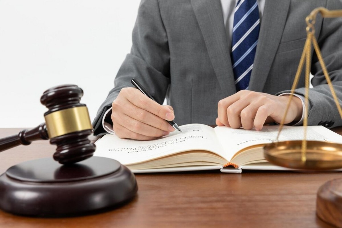 A legal expert is writing in a book in his office.