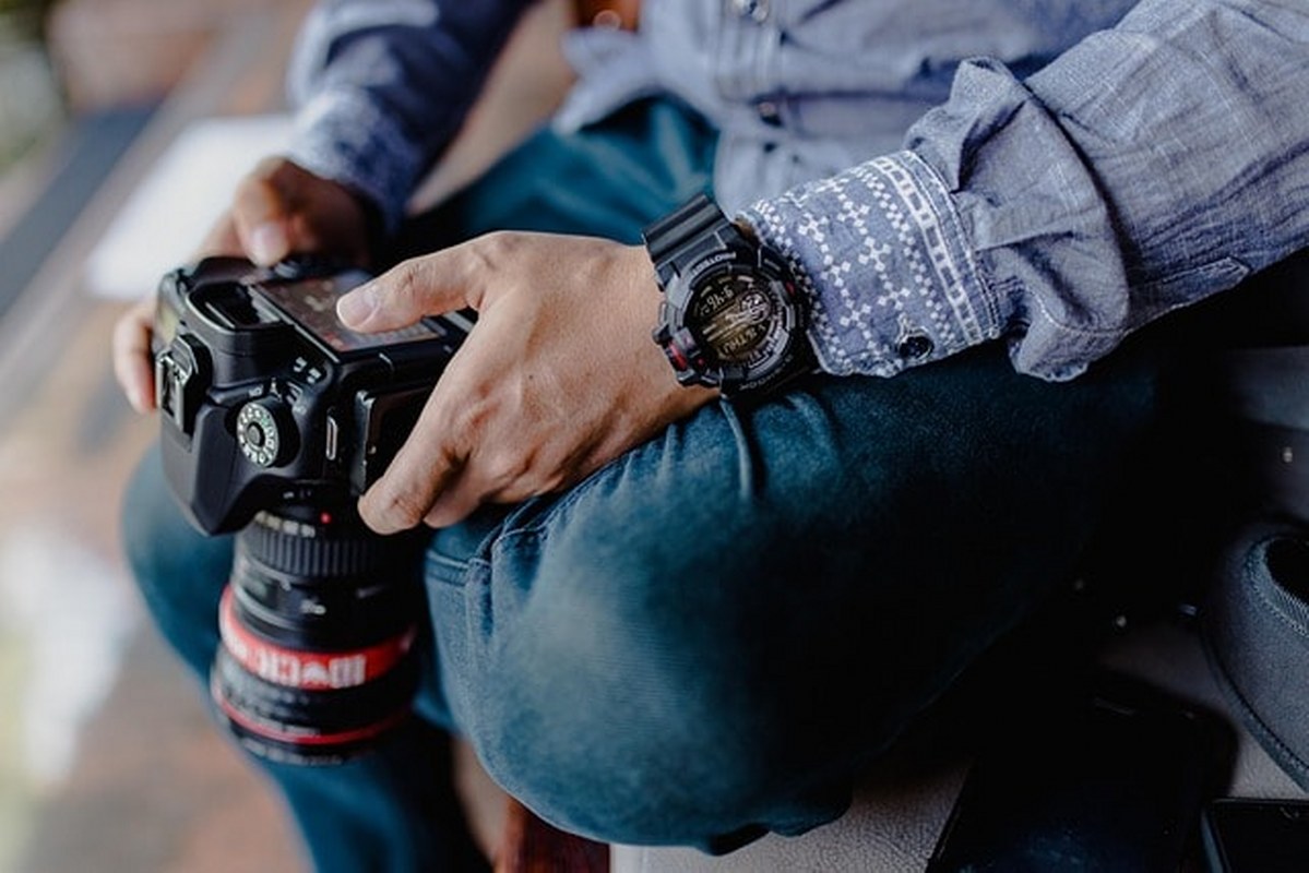 A man is configuring his DSLR camera.