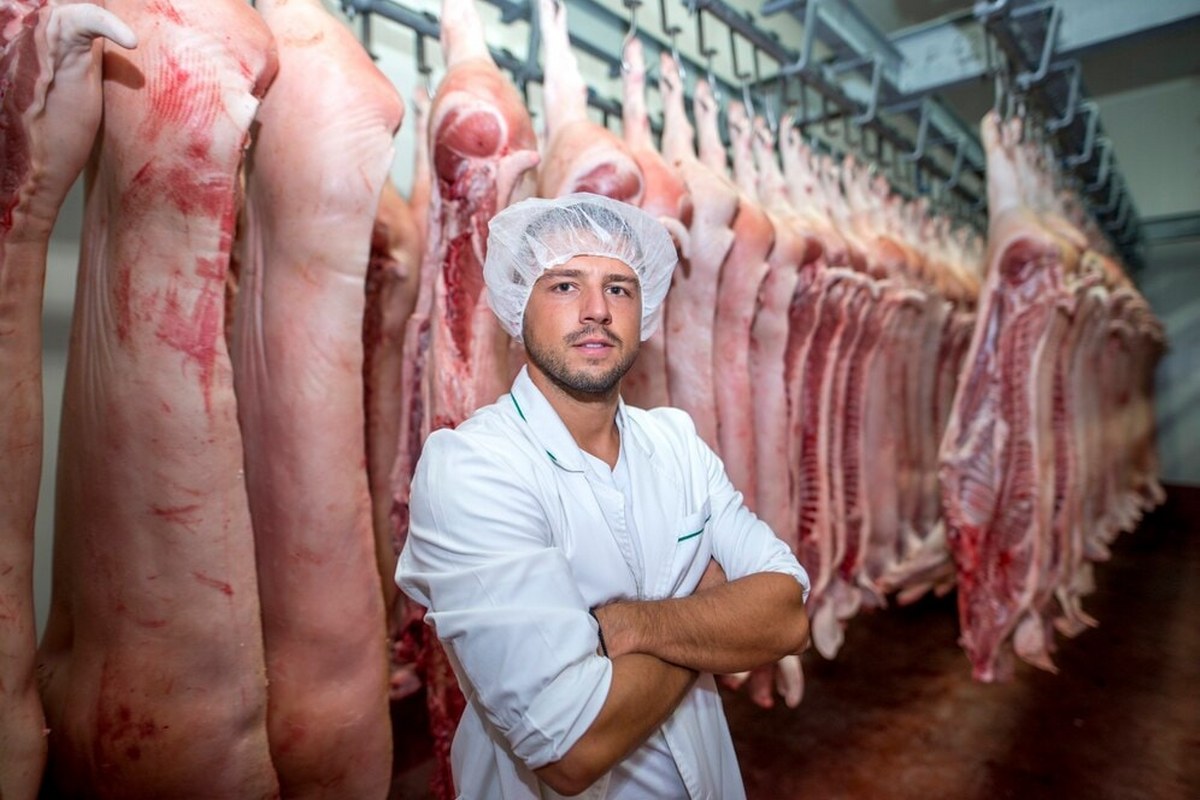 A man stands in a slaughterhouse.